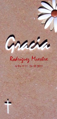 Lápida para panteón en mármol Ulldecona flameado con margarita incrustada en mármol blanco con textura abujardada en petalos de bajo relieve